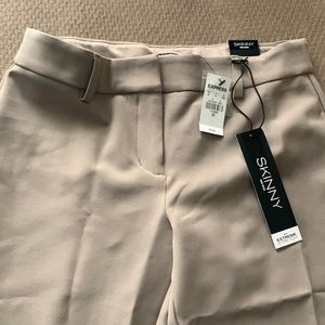 Skinny mid rise pants. Tan in color. Zipper and hook closure. Seam down back.
